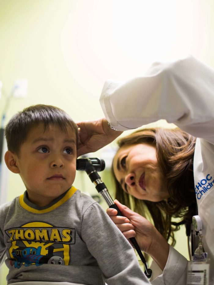 doctor checking young boy's ears