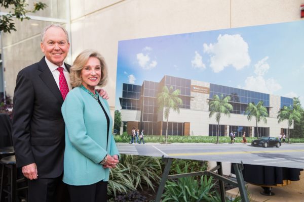 Billy and Nancy Thompson stand next to a mockup of the Thompson Autism Center 