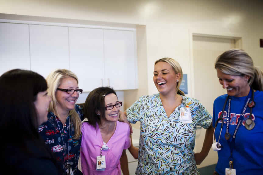 A group of CHOC nurses laugh while posing for a photo