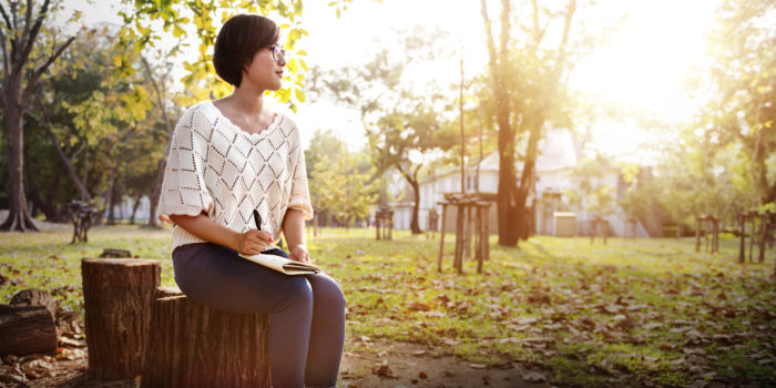 woman sitting in the park journaling