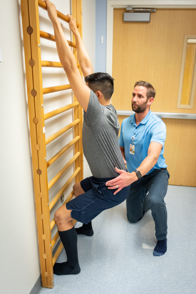 physical therapist helping patient stretch