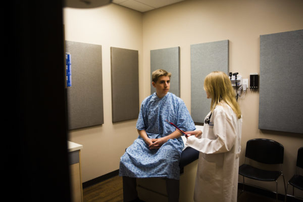 A CHOC Children's pediatric urologist speaks with an adolescent male patient in an exam room