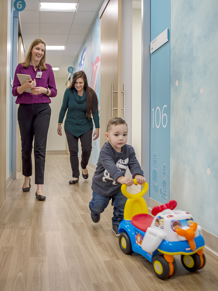 young boy pushing toy through CHOC Autism center hallway