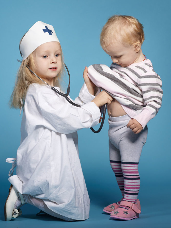 two cute little girls playing doctor
