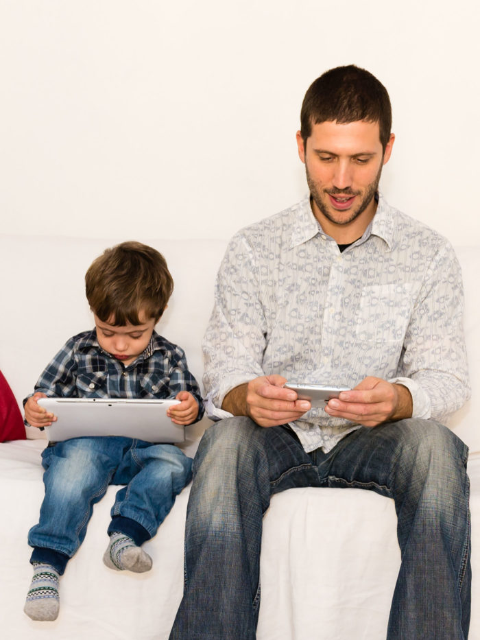 father and son playing with tablet
