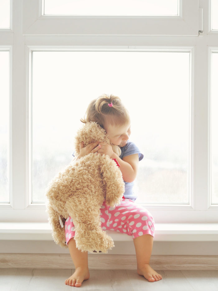 little girl hugging a teddy bear