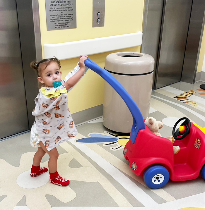 Luna pushing a large toy car at CHOC hospital