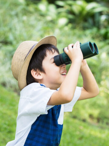 Child looks through binoculars. CHOC Research Institute discusses exciting future