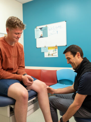 Dr. John Schlecter, orthopedic surgeon at CHOC, and looking a a teenage male patient's knee