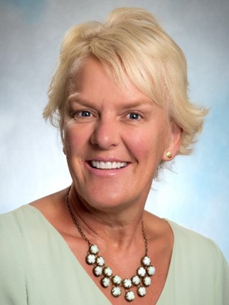 Dr. Terrie Inder - headshot of woman in green shirt smiling at the camera 