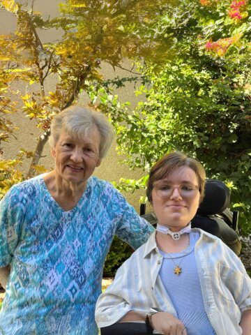 CHOC patient Kris Ewing with grandmother Pamela Ewing posing in front of trees.