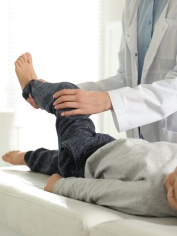 Doctor examines child's leg