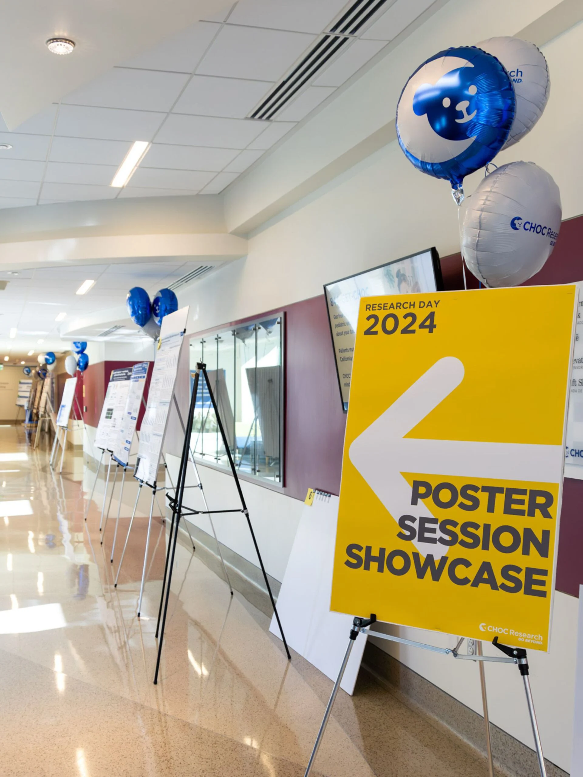 Research Day 2024 poster session sign with balloons in a hallway