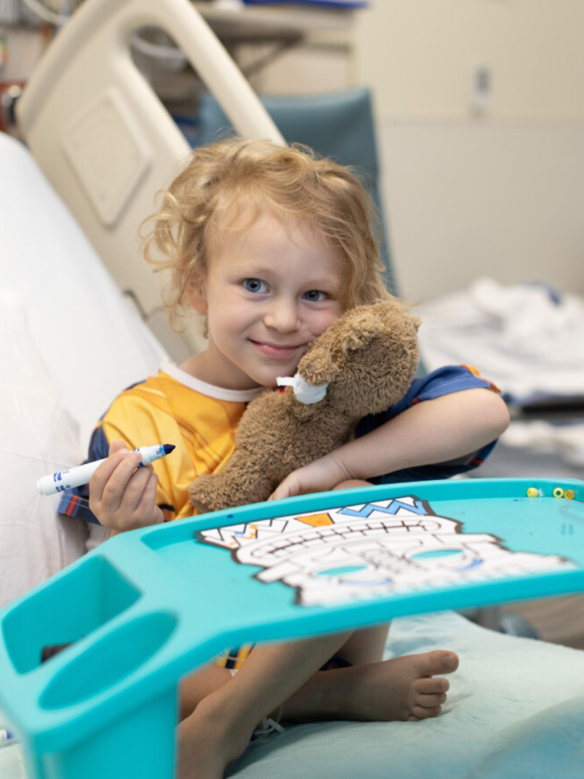 Smiling child in hospital bed.